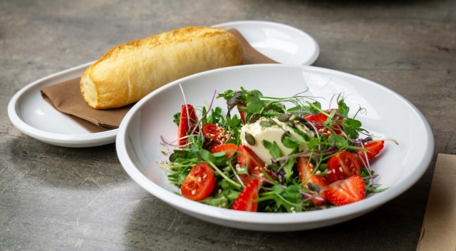 Goat cheese cream, salad with strawberries and arugula sprinkled with seeds, baguette